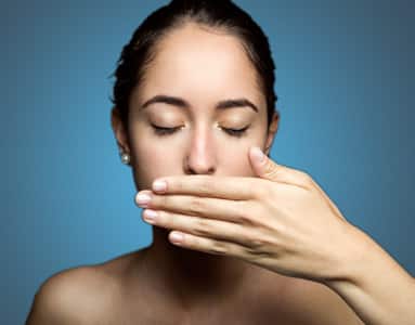 The woman covers the lower part of her face with her hand because she needs to reduce the risk of hypersensitivity reactions