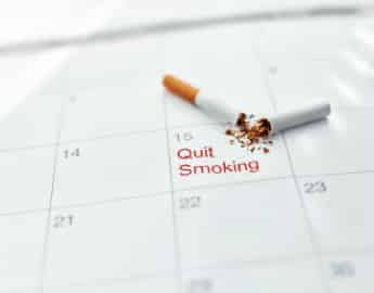 A cigarette broken in half lies on the calendar, which symbolizes a Smoking Cessation