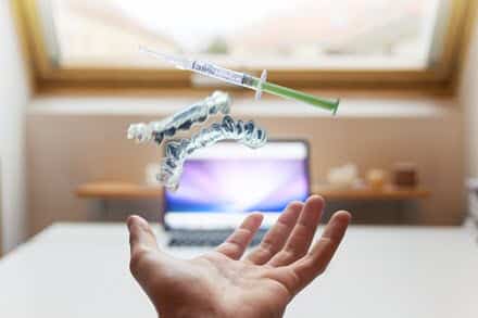 Flying hyaluronic acid syringe above the open hand