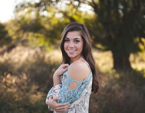 A young woman shows her cheeks improved with Juvederm