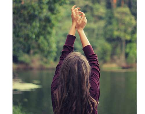 a woman raised her arms up after receiving botox treatment for her armpits