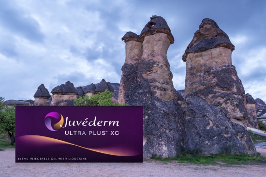 Juvederm dermal filler packaging with three stone towers in the background