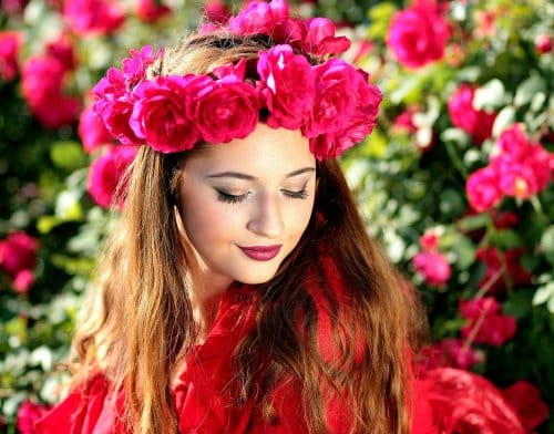 A beautiful woman with red flowers on her head shows the wonderful result using of Restylane for Nasolabial Folds