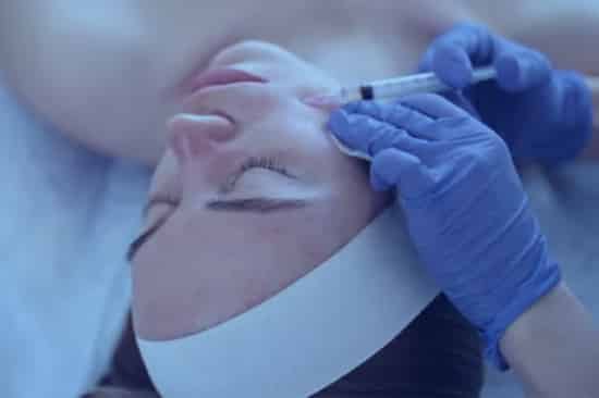 a woman receives a treatment with permanent dermal filler