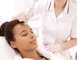 A woman receives a mesotherapy procedure on her forehead