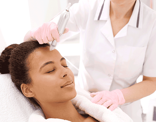 A woman receives a mesotherapy procedure on her forehead
