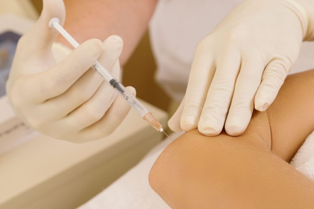 a person receives a Hyaluronic Acid Injection in the elbow