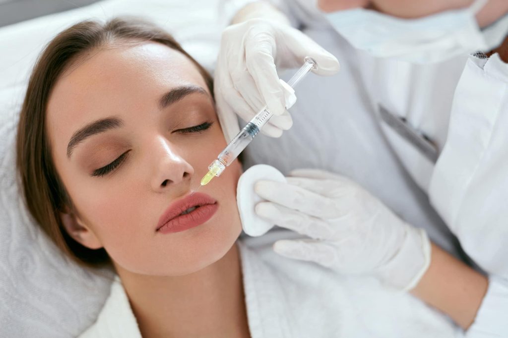 woman receiving dermal filler treatment for lips