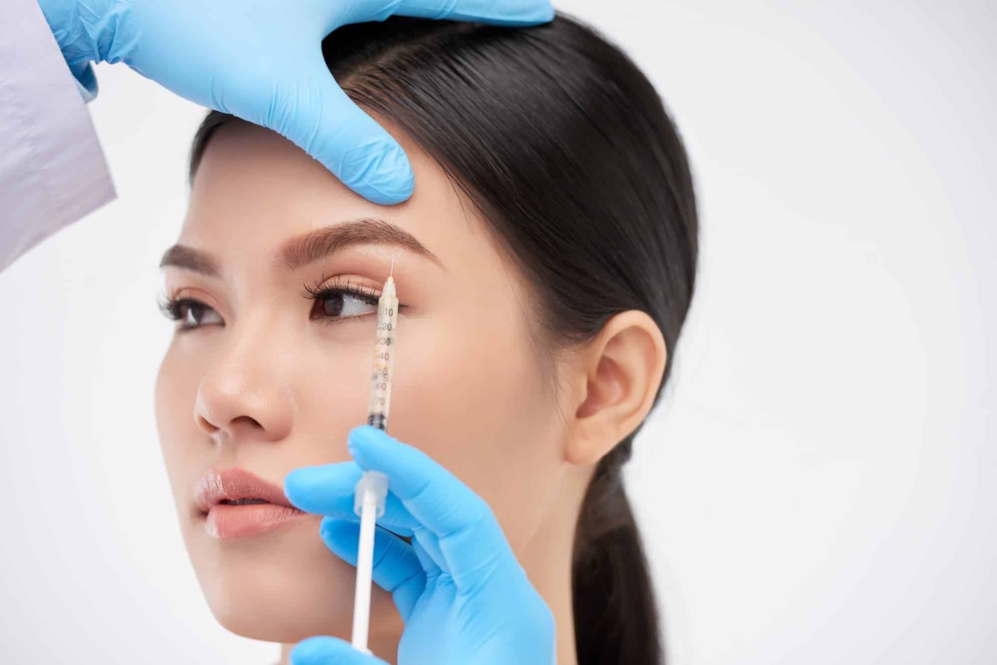 woman receiving eyebrow treatment