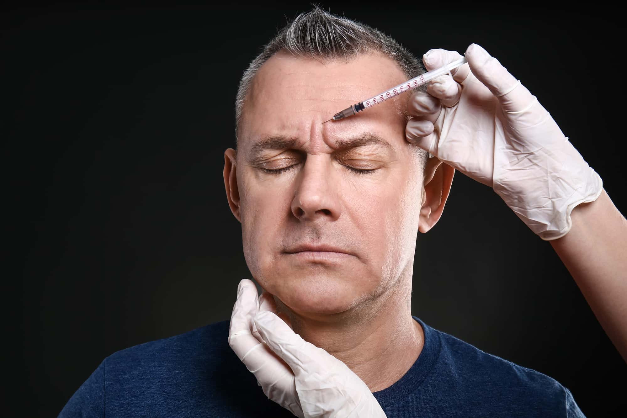 man getting botox injection in forehead
