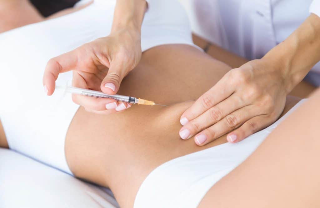 doctor giving an ozempic injection into the abdomen of a female patient