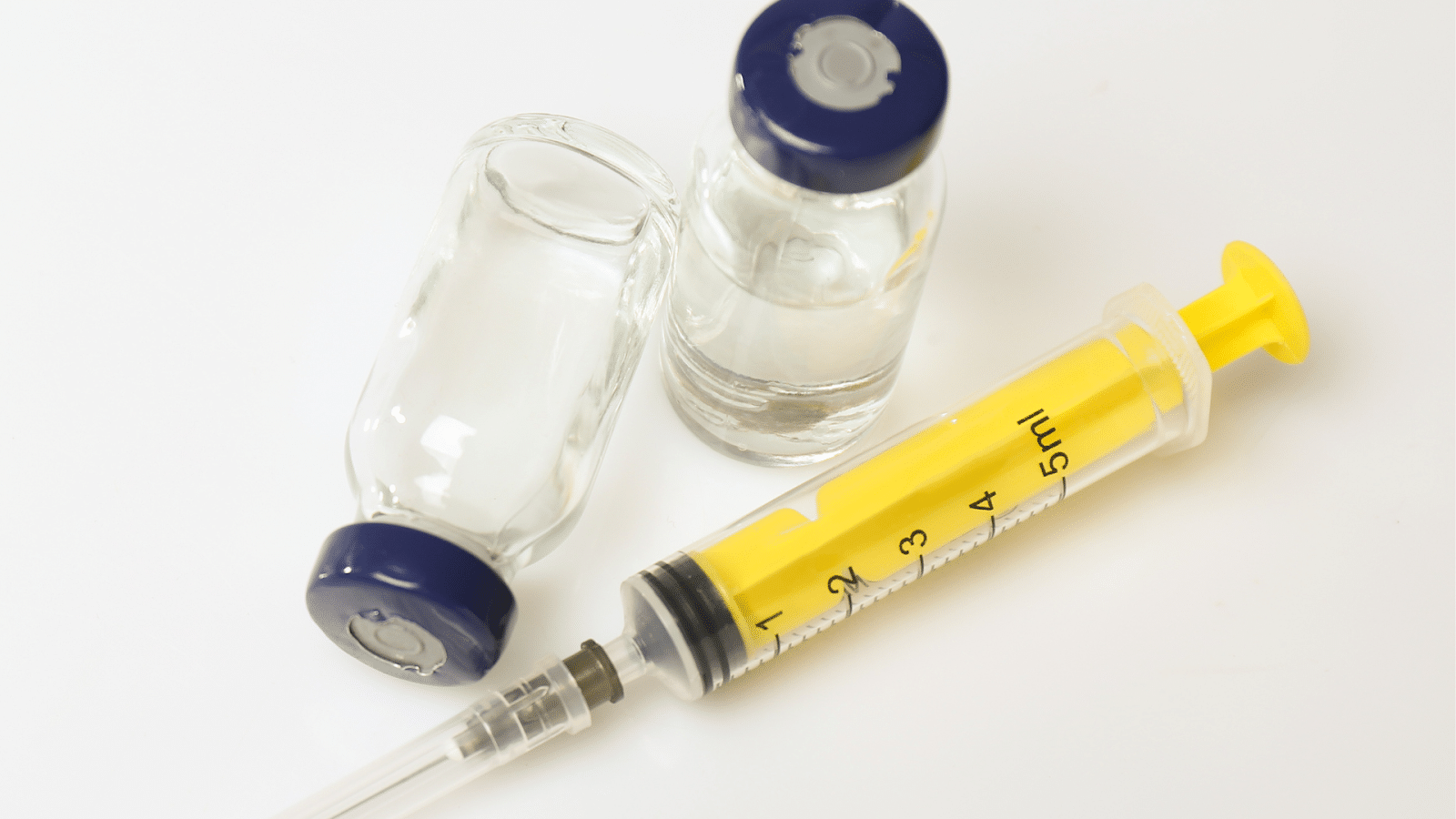 Vials and syringe on a table for dermal fillers.