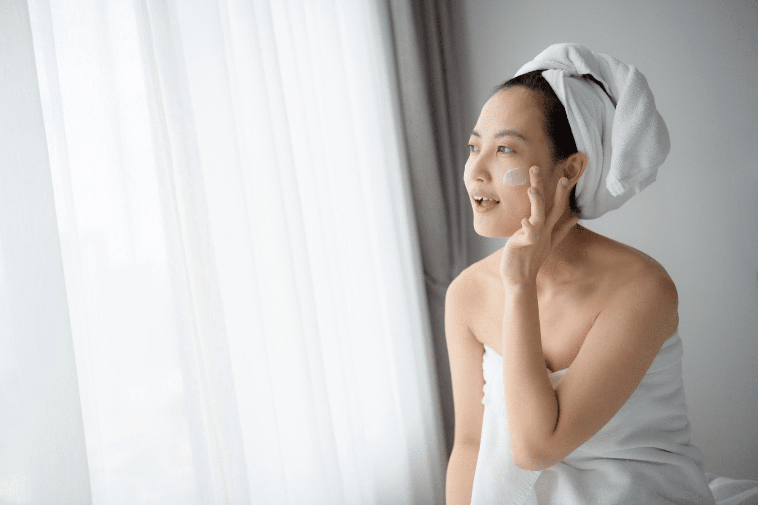 Happy young Asian woman applying sesderma to her face Daily makeup and skincare