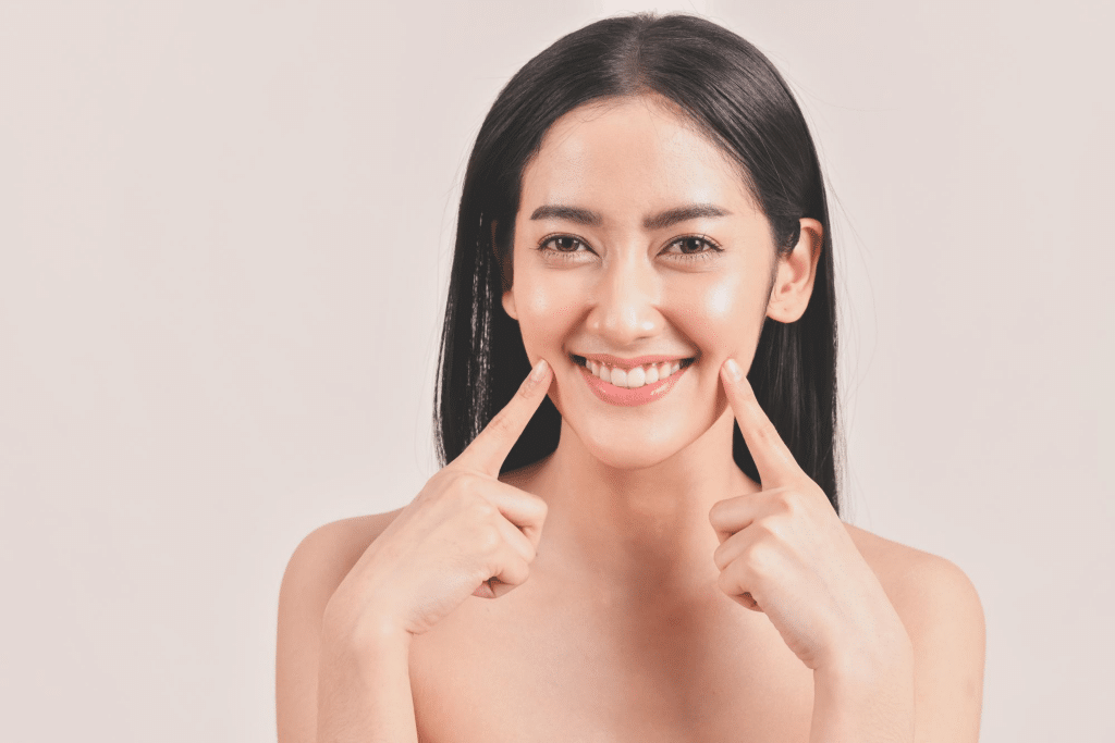 Smiling woman showcasing her facial skin after Aquashine booster treatment
