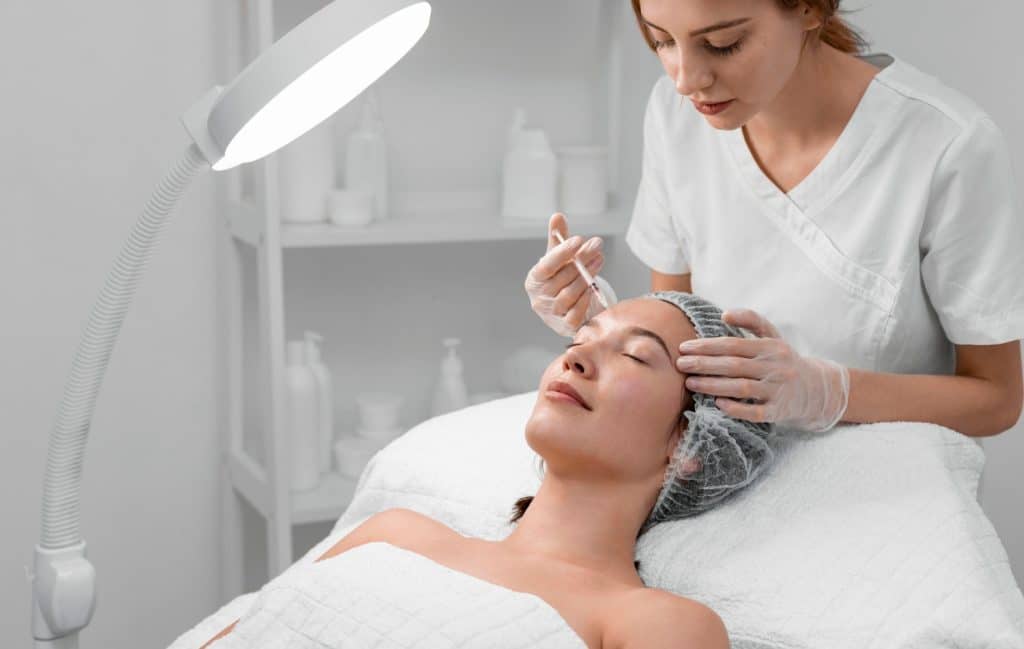 A woman receives neuromodulator injections in the forehead to treat wrinkles.