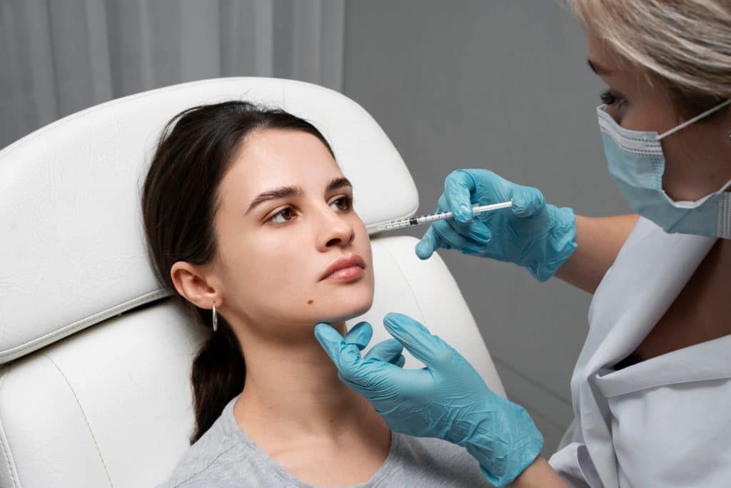 A doctor administers Dysport to the masseter muscle of a female patient.