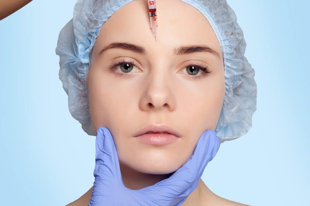 A young woman receives Dysport injection in the forehead to treat dynamic wrinkles.