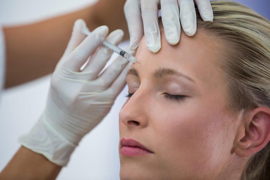 A healthcare professional precisely injects Dysport to achieve eyebrow lifting effect.