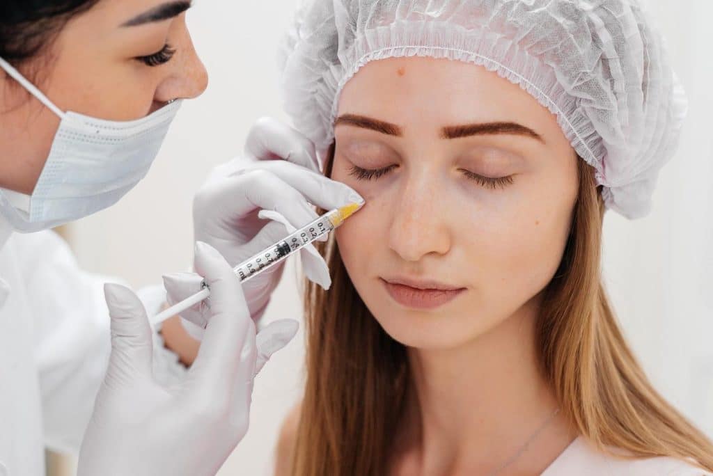 A female patient receives neurotoxin injection to improve the appearance of her under eyes.