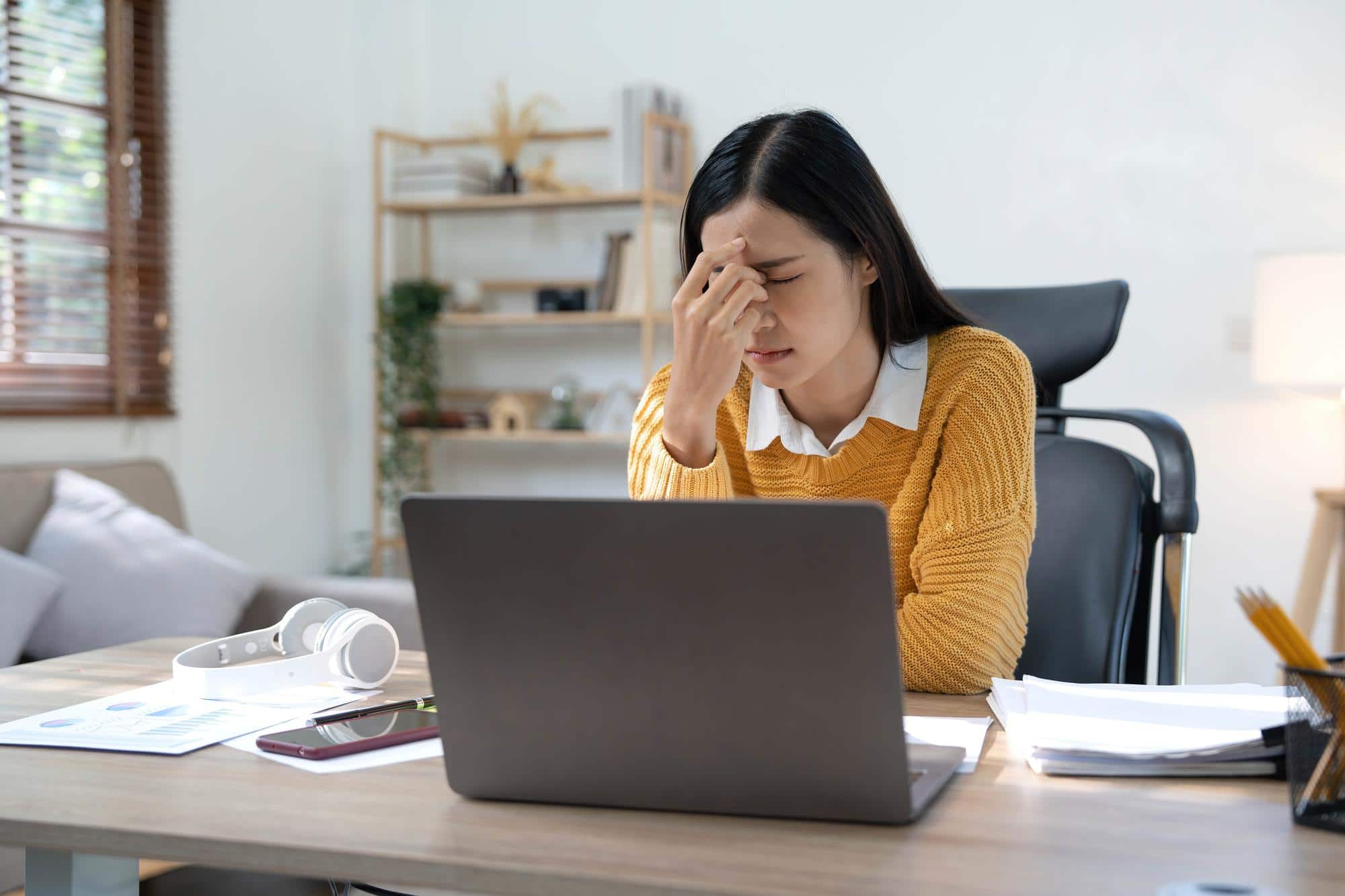 A woman's workday is interrupted because of tension headaches.