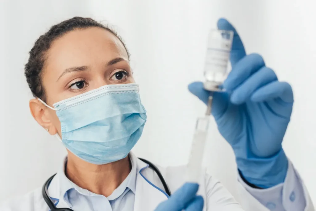 the doctor gets the injection ready for her patient
