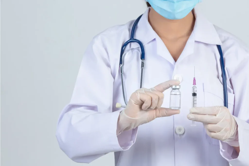 doctor holds the vial and the syringe