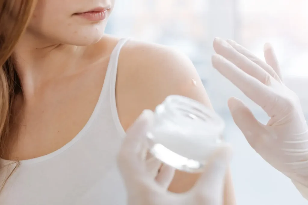 doctor putting cream on her shoulder before injection