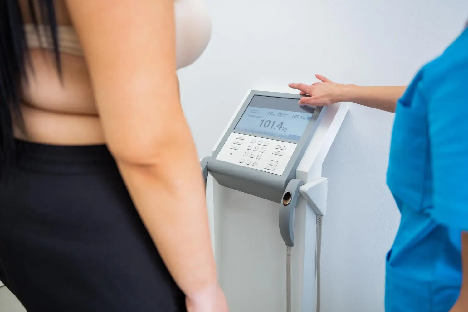 patient checks her weight in the clinic