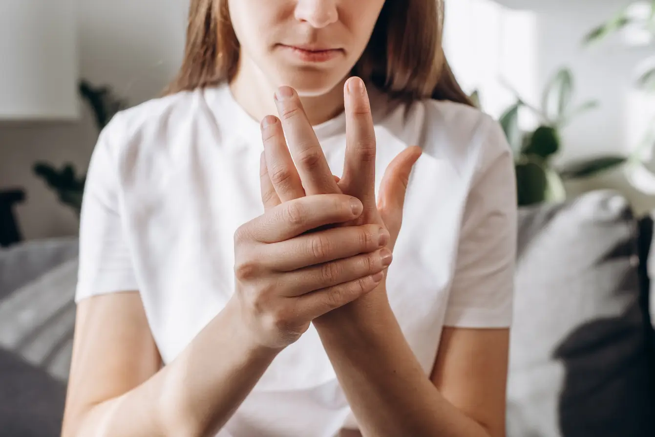 She massages her aching hand and fingers for relief.