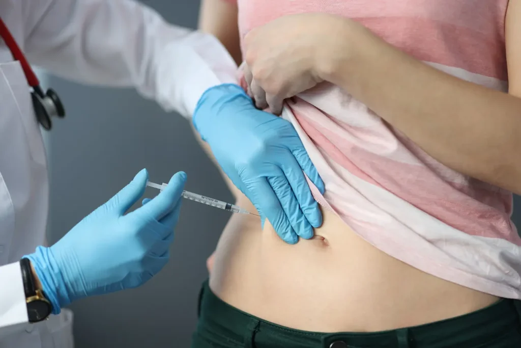 Doctor injects the treatment on the patient's abdomen.