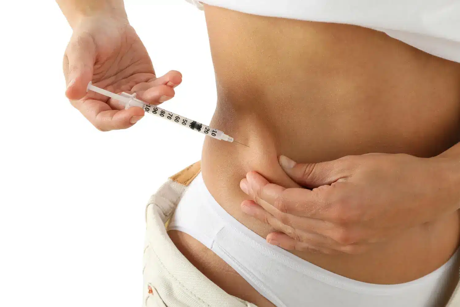 Woman's hands holding a syringe, preparing to self-inject into her stomach for treatment.