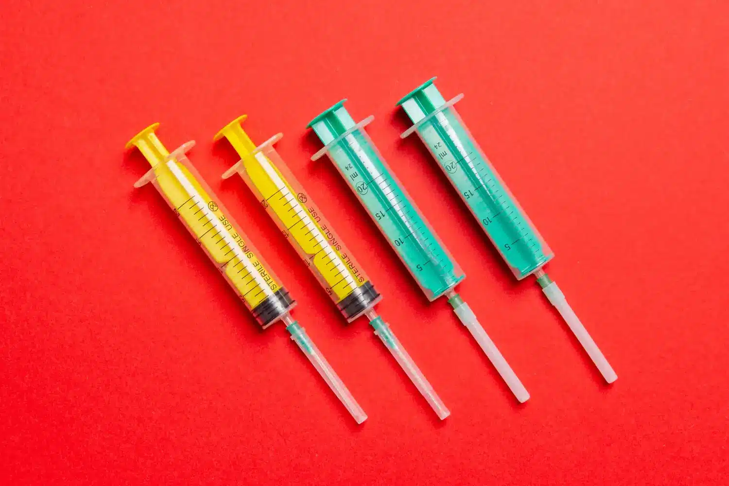 Four colorful syringes used as medical tools, probably for administering injectables like Cimzia for autoimmune diseases.