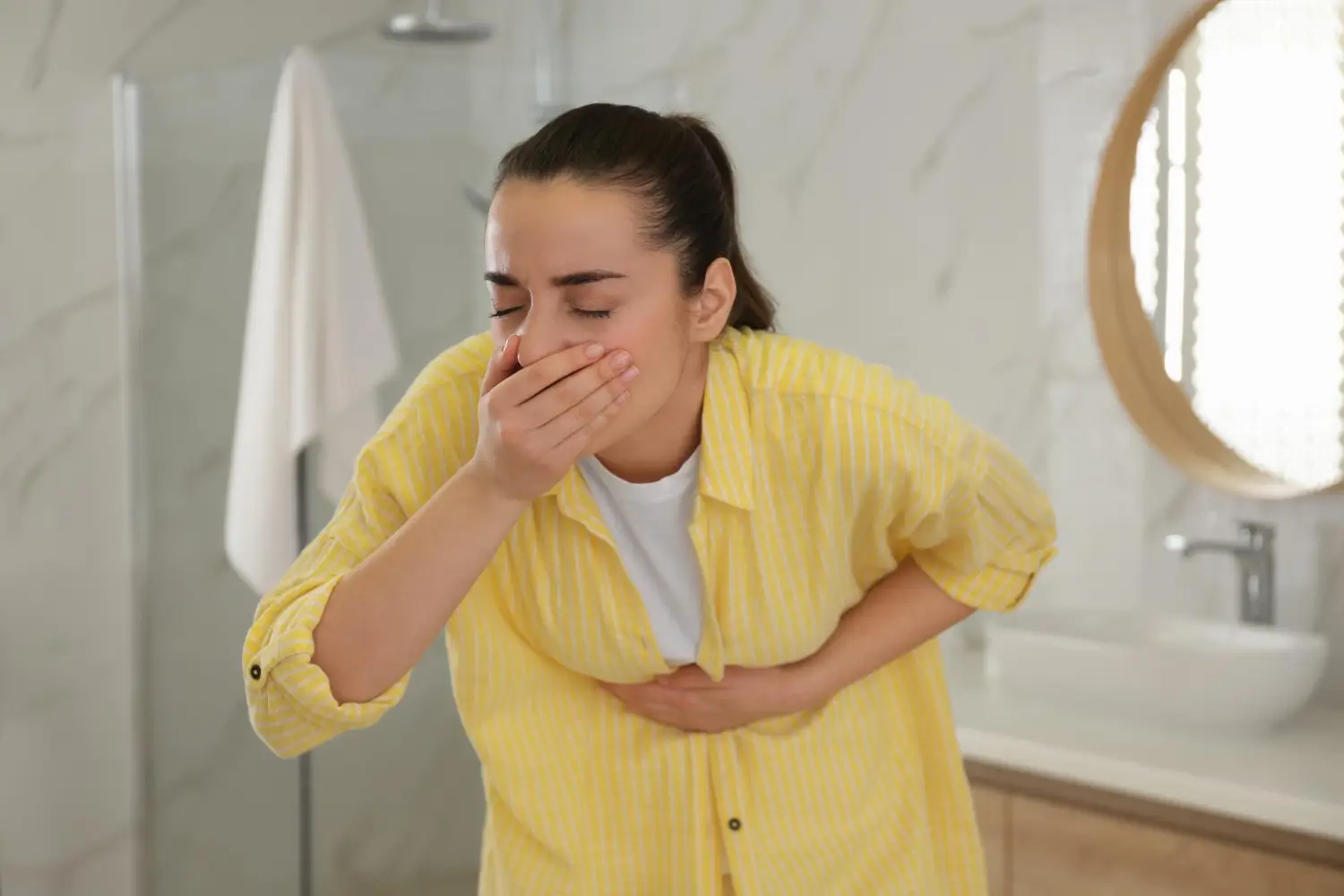 woman endures the pain in her stomach and vomits
