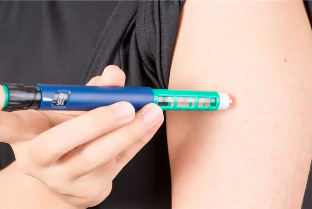 He injects the treatment pen on his arm as part of his weight loss journey.