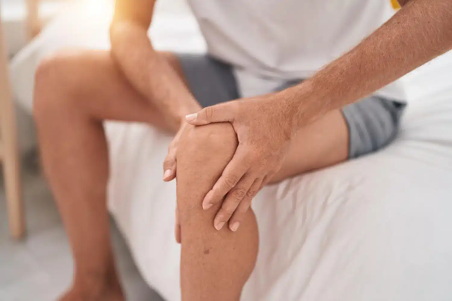 Person touching his aching knee for some relief.