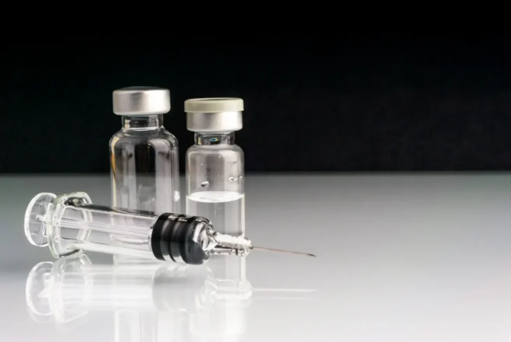 Syringe and medical vials ready for vaccination or medication delivery.