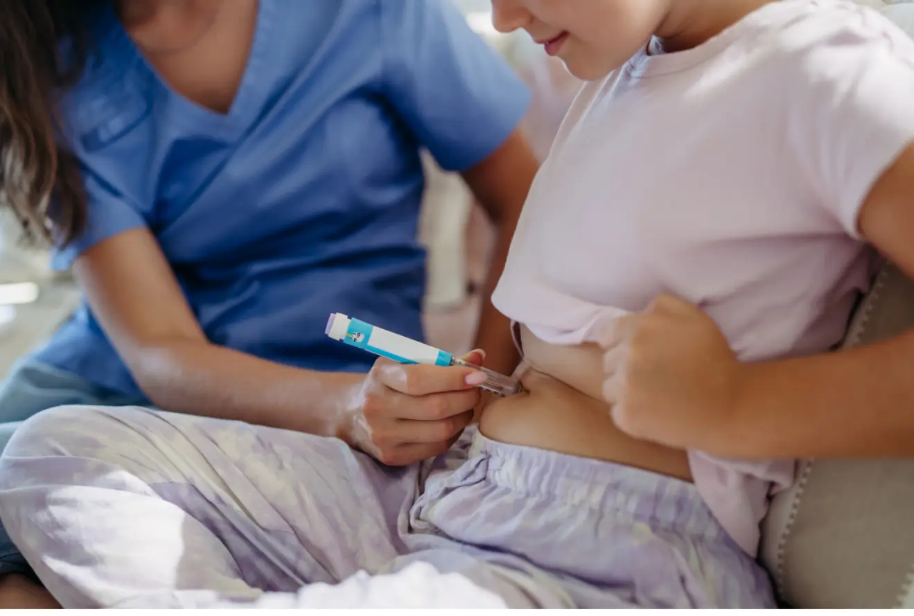 Nurse helps patient inject on her abdomen, probably an insulin treatment like Mounjaro or Wegovy.