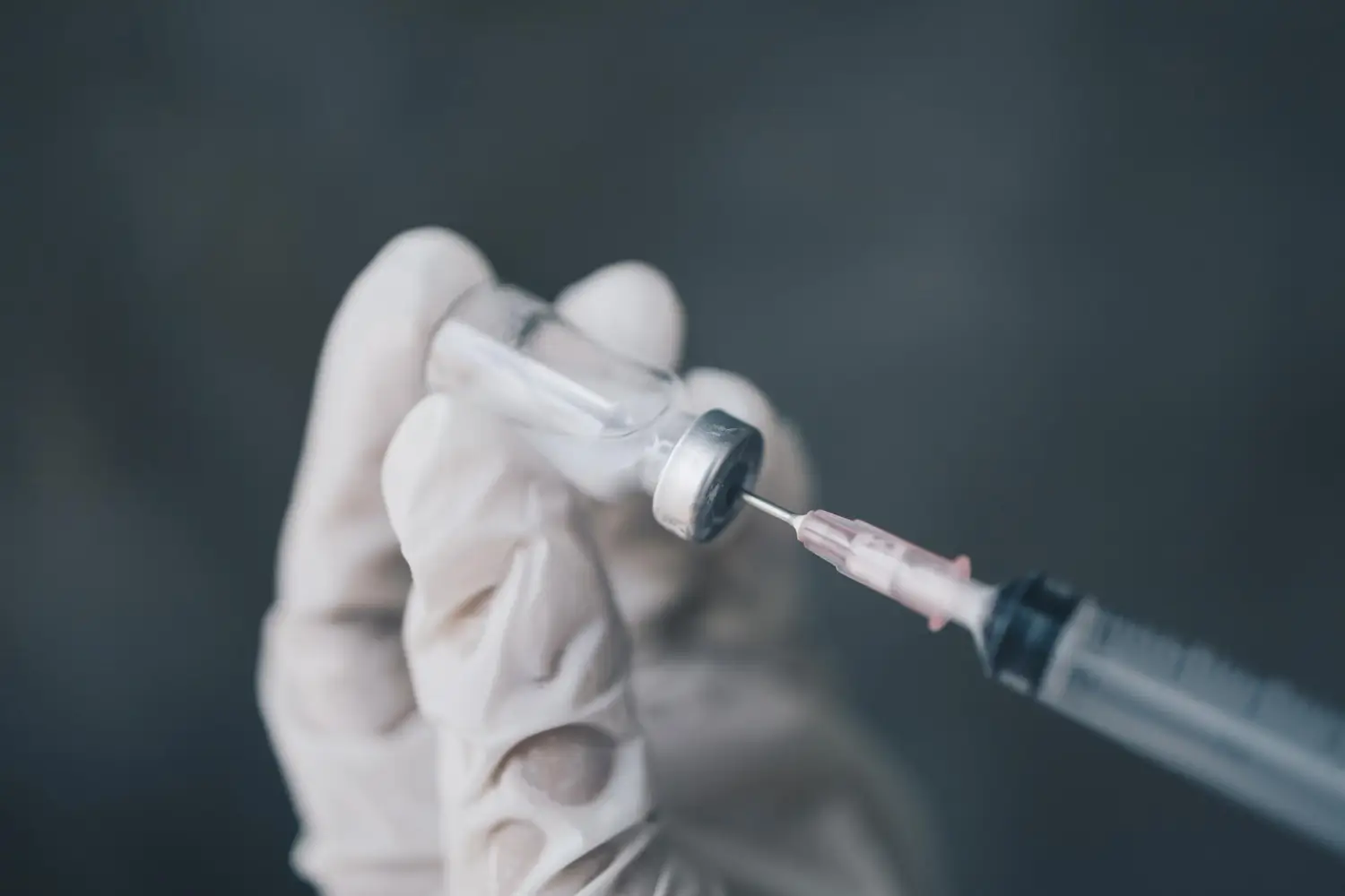 Doctor filling the syringe with the treatment for osteoarthritis, like Orthovisc or Synvisc.
