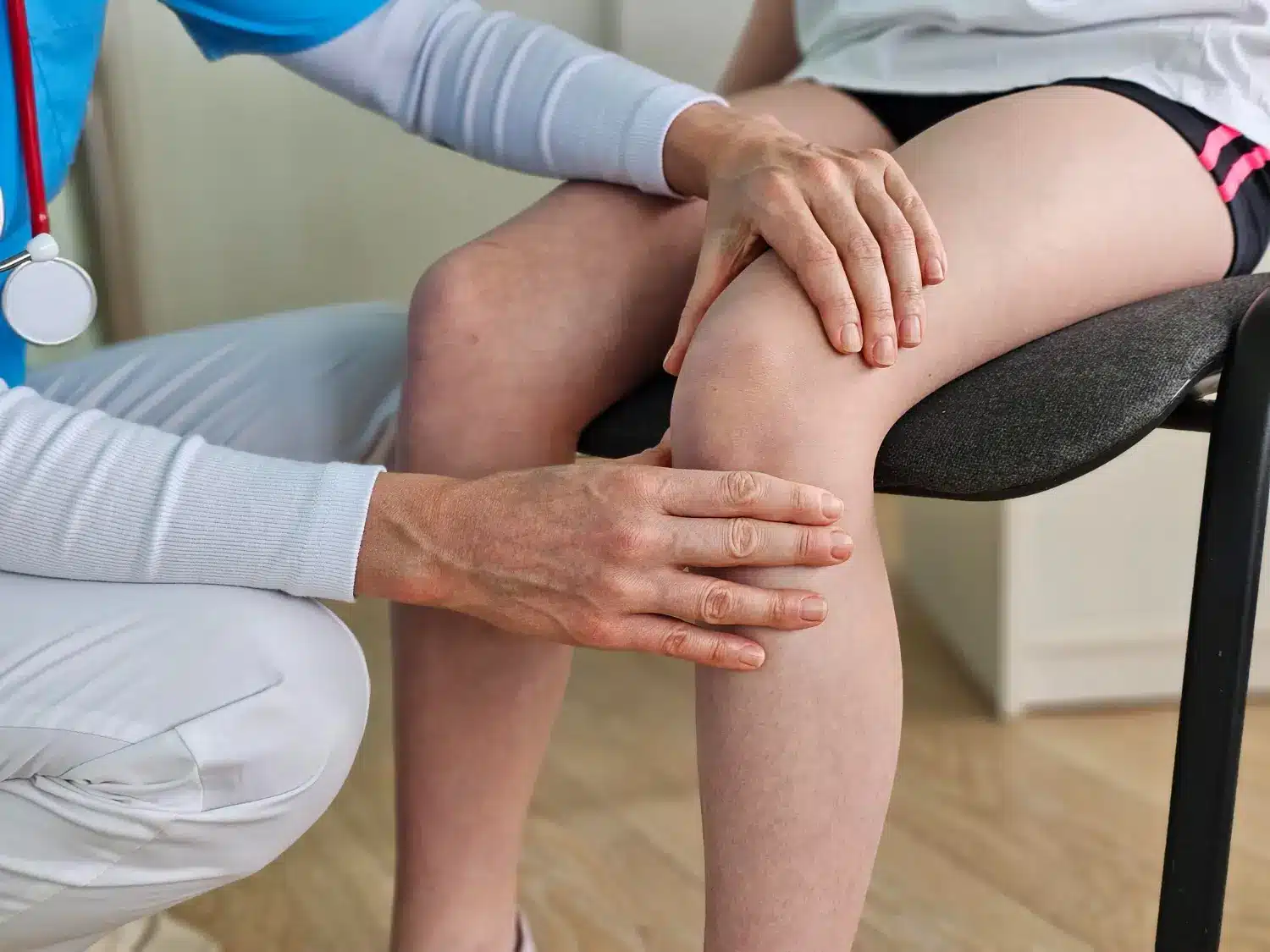 Physical therapist examining patient's knee. 