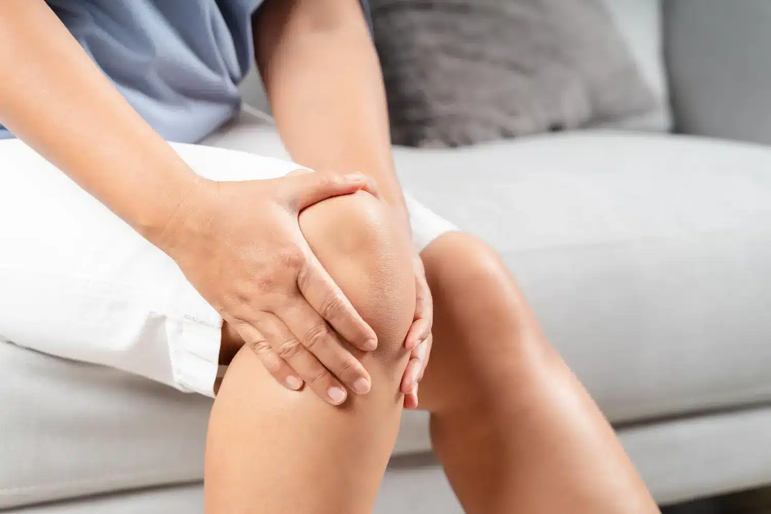 Touching the painful knee, seeking some relief.