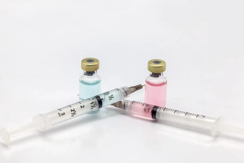 Colorful medication vials and syringes illustrate modern medical treatments for various health conditions.