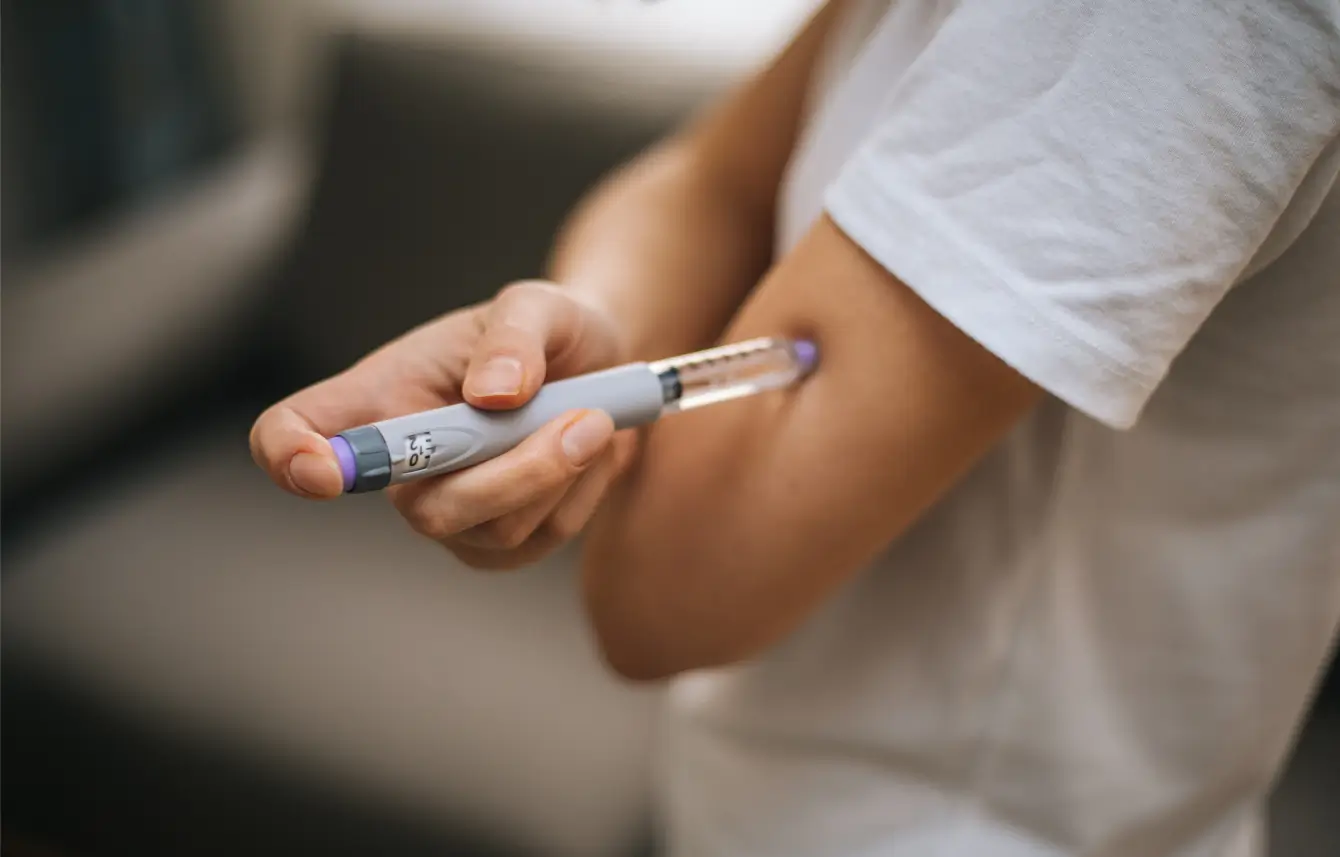 Patient self-injects insulin on her arm.
